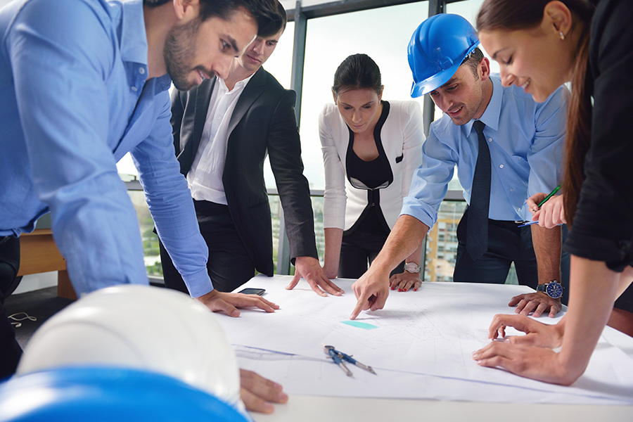 Business Insurance - Business People and Engineers in a Meeting Discussing Site Plans